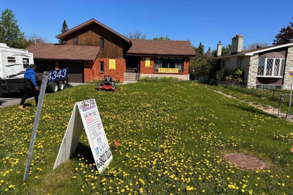 Lawn care service mowing a residential yard in Orléans Ottawa